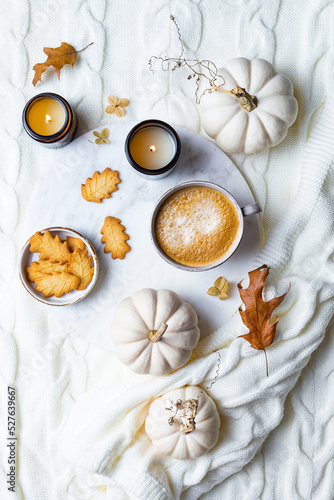 Fall cozy holiday background with cup of coffee, cookies, pumpkins and wool knitted plaid. Warm autumn mood flat lay. Breakfast in bed