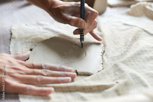 Female ceramist working in pottery studio. Ceramist's Hands Dirty Of Clay. Process of creating pottery. Master ceramist works in her studio