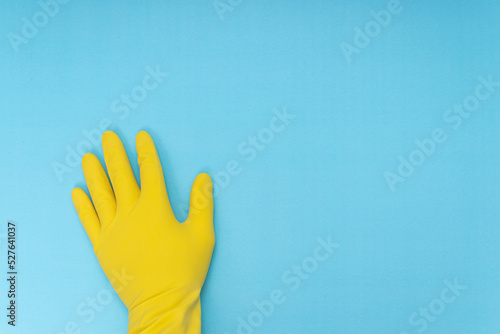 yellow cleaning glove standing on blue background.home cleaning