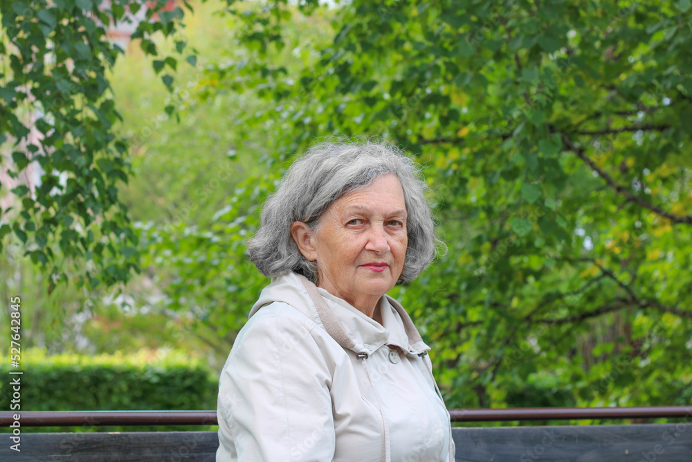 An elderly woman with gray hair is warmly dressed in cool weather. Retirement age An elderly woman with gray hair is warmly dressed in cool weather. Retirement age