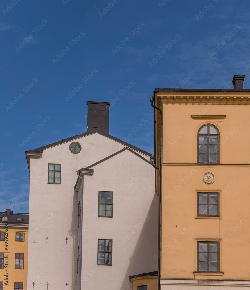 Facades of old 1700s court houses a sunny day with cumulus clouds in Stockholm