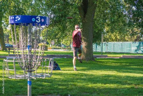 Disc golf, a flying disc sport played using rules like golf, being played by a middle aged man on a nine hole course in  Ashbridges Bay Park in Toronto’s Beaches neighbourhood in late August. photo