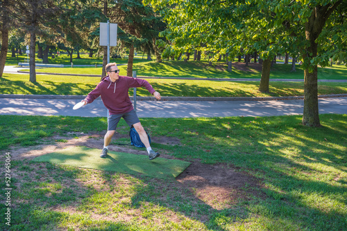 Disc golf, a flying disc sport played using rules like golf, being played by a middle aged man on a nine hole course in  Ashbridges Bay Park in Toronto’s Beaches neighbourhood in late August. photo