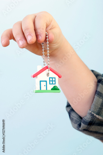 Boy is Looking to a House Key Against Blue Background
