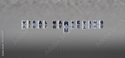 viral marketing word or concept represented by black and white letter cubes on a grey horizon background stretching to infinity