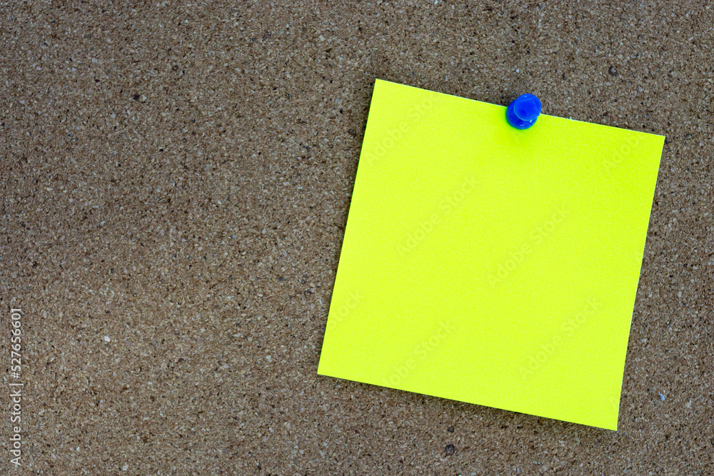 Yellow stick note and pinned to a cork notice board. Copy space. Yellow stick note and pinned to a cork notice board. Copy space.