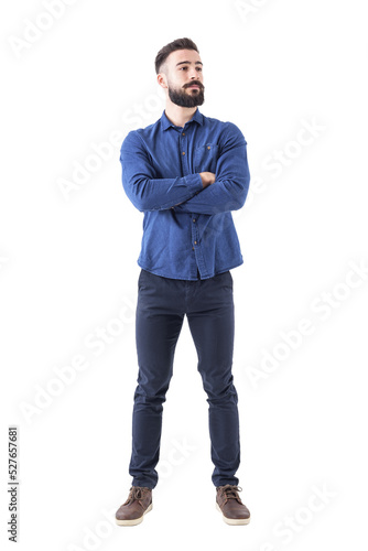 Confident cool young bearded man standing and looking away with crossed hands. Full body isolated on transparent background. photo