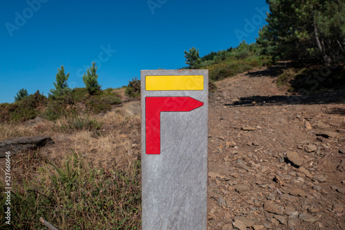Placa de sinalização a meio de uma trilha a informar os caminhantes que se deve virar à direita photo