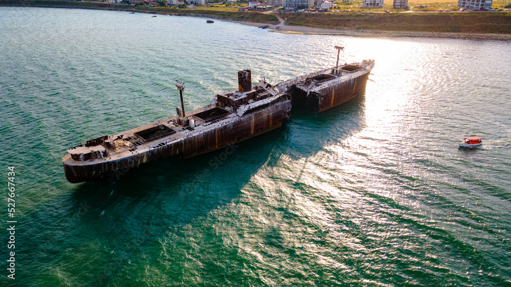 Drone photography of a rusty shipwreck at the Black Sea located next to Costinesti beach, in Romania. Aerial photography shot from a drone at a higher altitude.