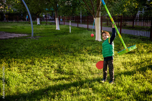 Happy boy is playing tetherball swing ball game in summer campin photo