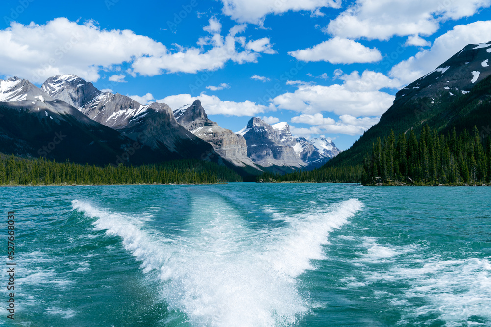 Maligne Lake as seen from the water, on a sunny summer day in Jasper National Park Canada, with boat wake in photo