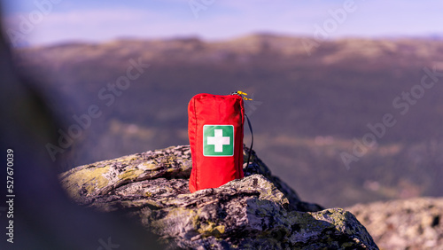 First aid kit in red case is ready for big hiking trip in mountains