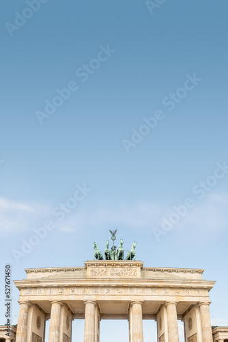 Cover page with quadriga, four horses lead by Viktoria, Roman goddess of victory at Brandenburg Gate (Brandenburger Tor) in Berlin historical downtown, Germany, at summer day, blue sky and copy space.