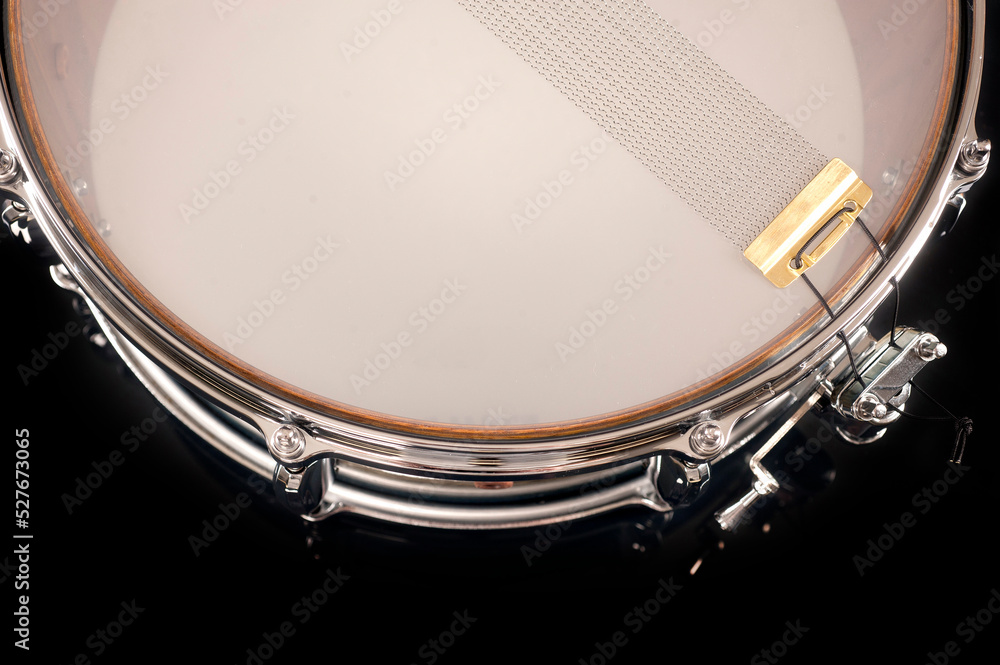part of a snare drum with a string on a black background with ...