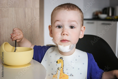 the child eats food with a bandage on his chin. Pain, injuries of children. Broken chin. Painful to chew food