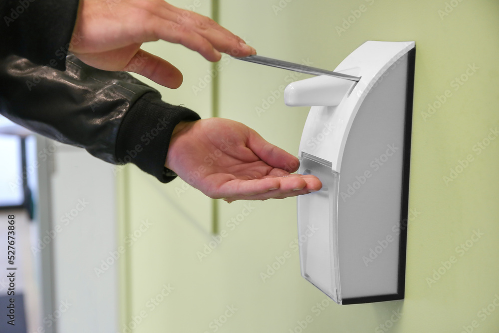 male hand with antibacterial gel from automatic sanitize machine hanging on building wall healthcare concept outdoor male hand with antibacterial gel from automatic sanitize machine hanging on building wall healthcare concept outdoor