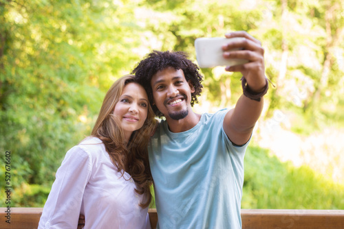 Young mixed race couple taking selfie in the summer nature