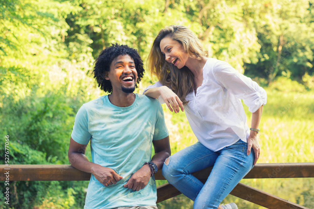 Young mixed race couple talking while standing in the summer nature Young mixed race couple talking while standing in the summer nature