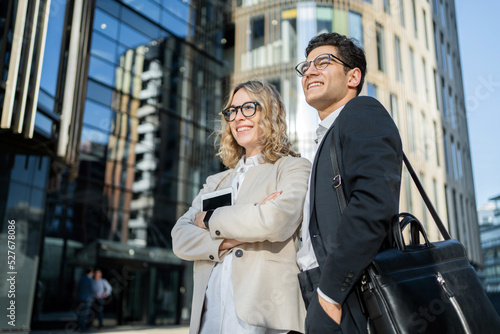 Business colleagues meet a team a woman and a man in business suits go to the office © muse studio