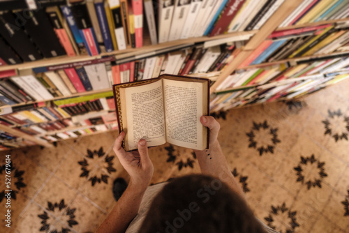 Aerial view of man reading a book in home library