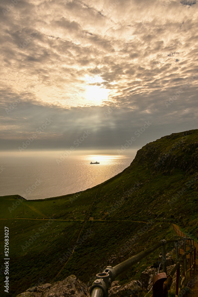 Schiff fährt übers Meer bei dramatischem Sonnenuntergang am Neist Point, Isle of Skye, Schottland