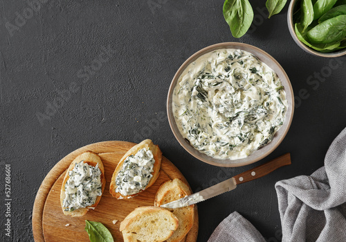Spinach appetizer or dip with bread, top view, dark background, copy space photo