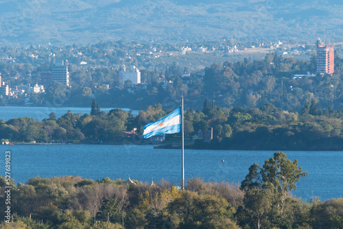 paisaje del Lago San Roque en la provincia de Cordoba, Argentina. vista del mastil con la bandera Argentina y de fondo la ciudad de Carlos Paz y las sierras chicas photo