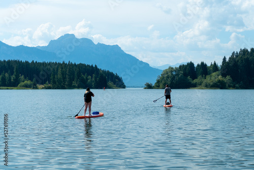 Couple at the Forggensee doing stand up paddling during summer, Bavaria Germany © Tobias