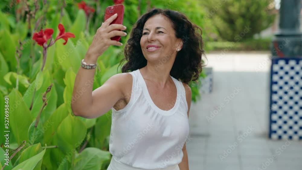 Middle age woman smiling confident making selfie by the smartphone at park Middle age woman smiling confident making selfie by the smartphone at park