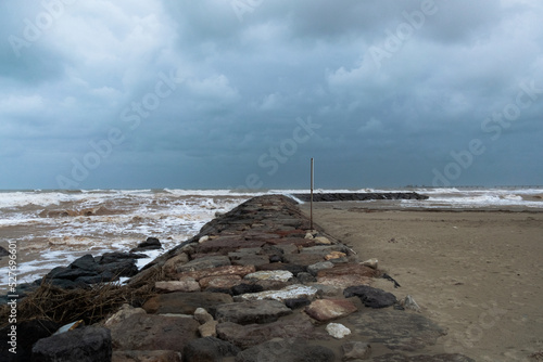 Sea with strong waves produced by the storm crashing against the jetty under a dramatic sky. Port of Sagunt - Valencia