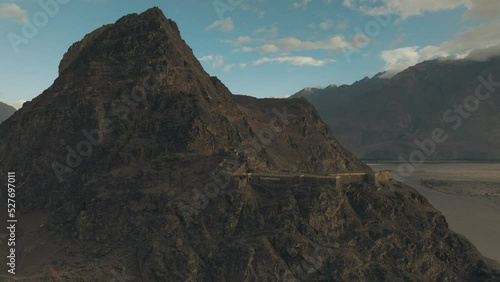 4K AERIAL, drone orbits around the ruins of an old stone fort in the Himalayas, shot during sunrise (golden hour). Kharphocho fort, Skardu, Gilgit Baltistan, Pakistan  photo