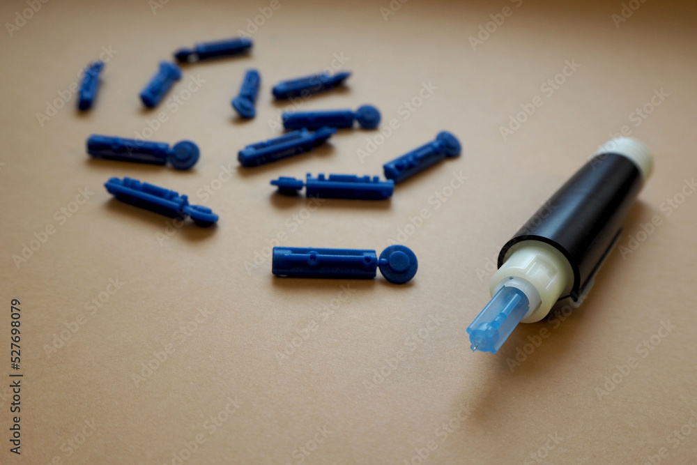 Naklejka premium a blood glucose meter with a needle on a brown background. measurement of blood glucose levels. diabetes