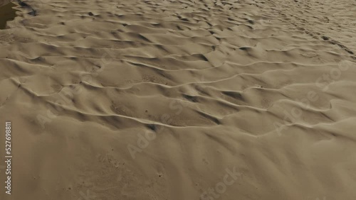 Drone flights in top of sand dune desert with camara pointing down and tilting up as it goes revealing that dunes are dunes are in the mountains, Pakistan Himalayas, Shigar, AERIAL 4 k photo