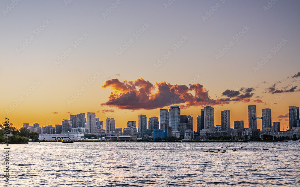 Looking across Toronto's Inner Harbour with the city skyline, and airport and the sunset in the background.