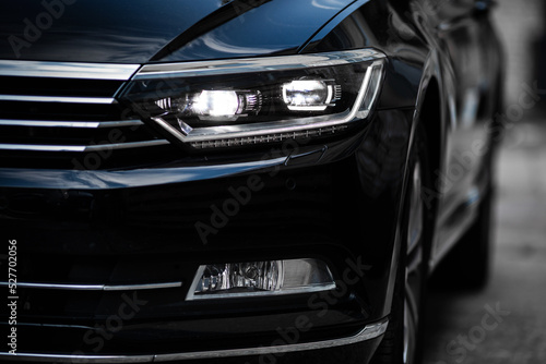 Headlights of modern black car close up.