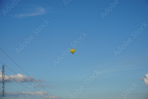 Latający balon na niebie i widoczne linie elektryczne