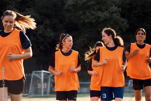 Fényképezés Female soccer players talk while running during sports training at stadium