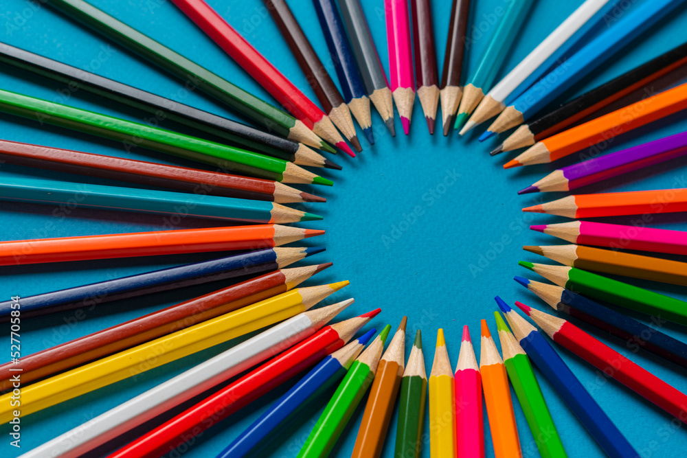 creative idea of colorful crayons making a circle shape on the pastel background