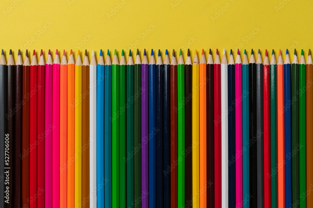 row of set of colored pencils flat lay on pastel background row of set of colored pencils flat lay on pastel background