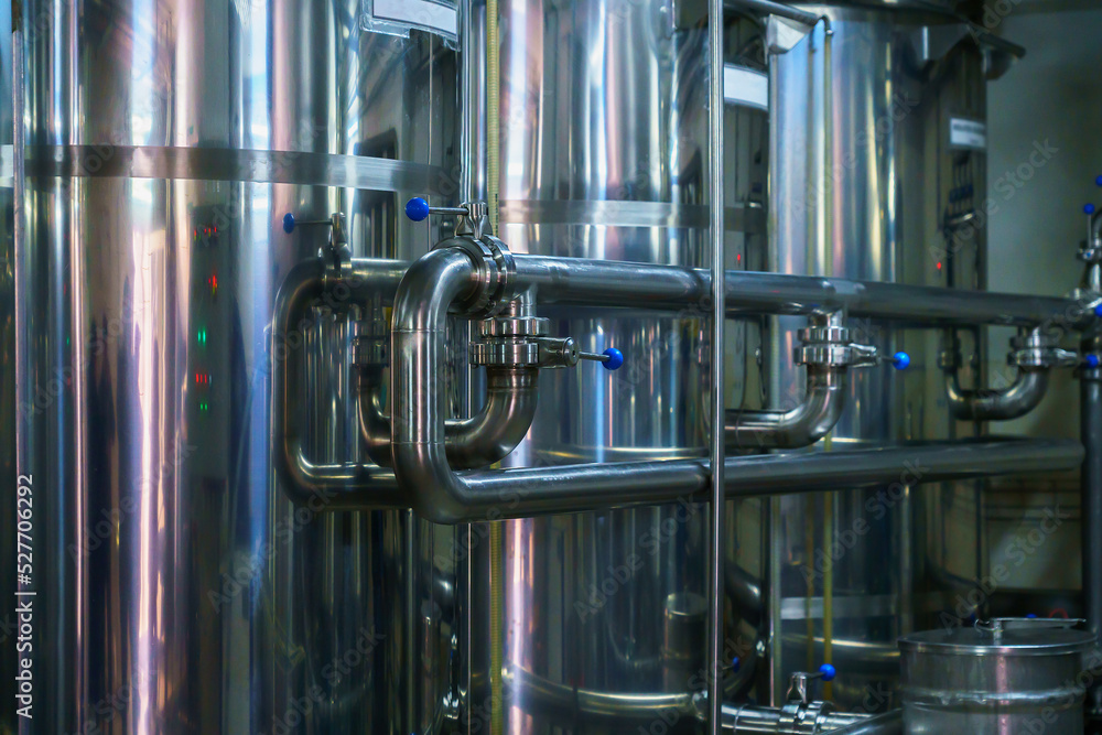 A stainless steel pipe system in the food industry at a brewery in the process of brewing beer. Background