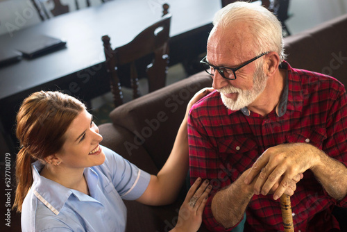 Fotografie Senior man with young nurse at home getting home care