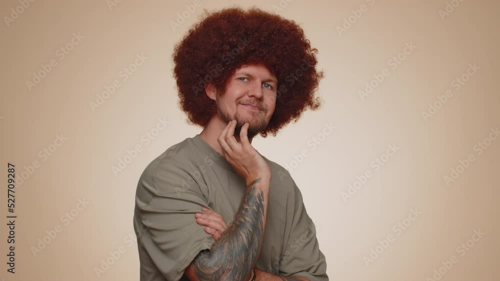 Smiling playful happy man in t-shirt blinking eye, looking at camera with toothy smile winking and flirting, expressing optimism. Young handsome adult guy alone isolated on beige wall background Smiling playful happy man in t-shirt blinking eye, looking at camera with toothy smile winking and flirting, expressing optimism. Young handsome adult guy alone isolated on beige wall background