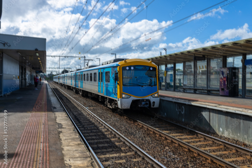 Fototapeta premium Commuter train approaching a train station in Melbourne Victoria Australia