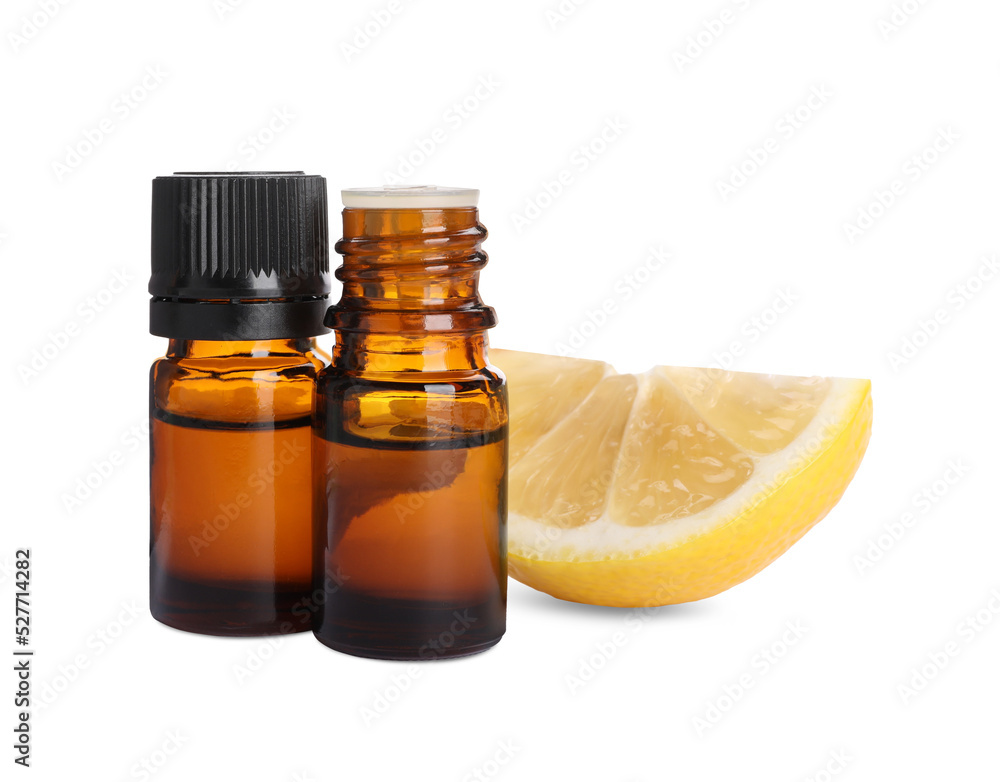 Bottles of citrus essential oil and cut fresh lemon isolated on white Bottles of citrus essential oil and cut fresh lemon isolated on white