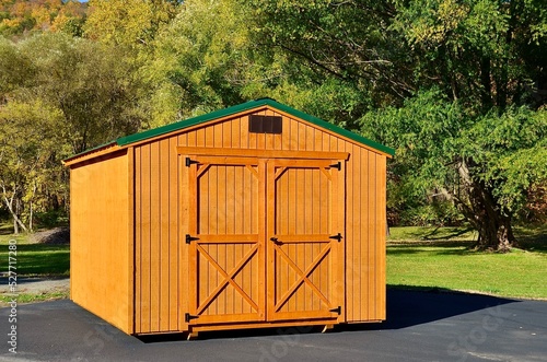 American style wooded shed. A shed is typically simple, single-story roofed structure in a back garden or on an allotment that is used for storage, hobbies, or as a workshop. Exterior view