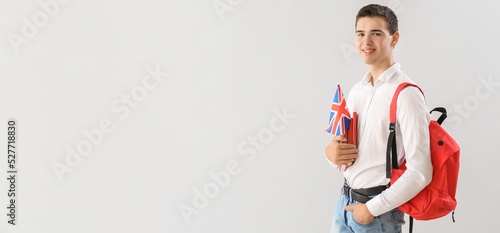 Young male student with UK flag on light background with space for text