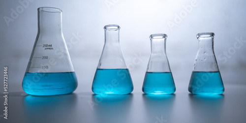 chemical science laboratory with blue liquid in test tube beaker and glassware equipment, research term of biology or chemistry and medicine biotechnology experiment working on scientific glass