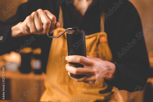 barista holding hand grinde...