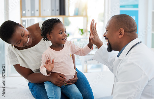 Fotografie Healthcare, mother and girl gives doctor high five in a doctors office