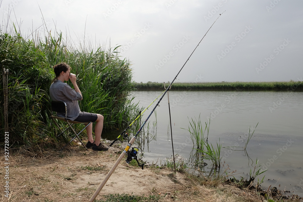 girl fishing catches fish against the backdrop of a picturesque landscape girl fishing catches fish against the backdrop of a picturesque landscape